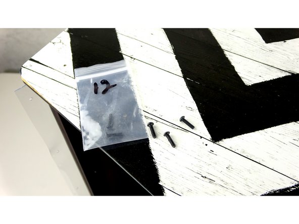 Carefully align and press the other side panel into place, making sure to catch the tabs of the Center Track Guide and Front Exit plate.