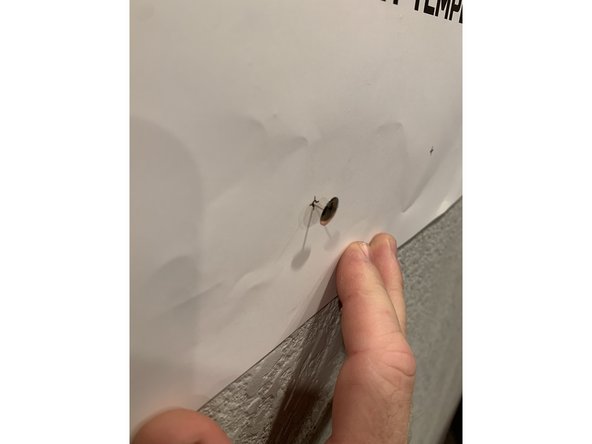 Use another pushpin or nail head or similar pointy object to punch through the mounting hole locations on the template.