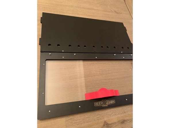 With the latch in the locked position as pictured, slide the nested together handles over the horizontally oriented key and run two 16mm screws through the seated square nuts from the backside of the lid to attach.