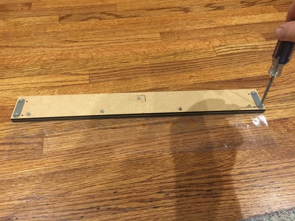 Note that there are four holes on the outer edges of the rear faceplate. Using the 1/4" phillips head screws from the fastener bag and a screwdriver, fasten the maglatch plates to the ends of the rear faceplate CLOSEST TO THE EDGE. Repeat this process for both sides.