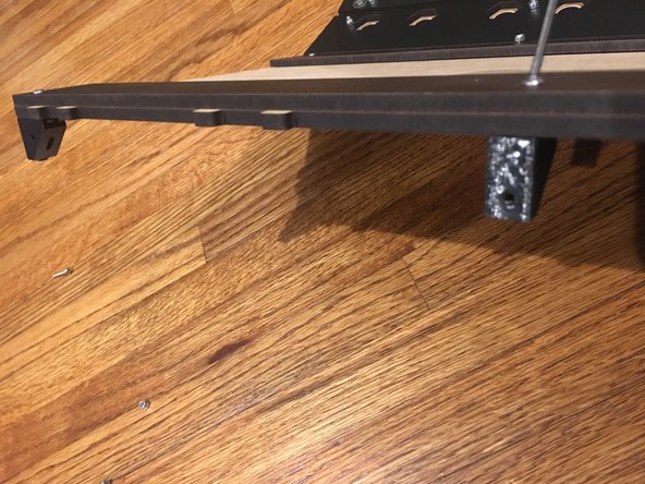 After lining up the Rear Track Guide on the  unfinished side of base panel, insert 16mm bolts through the rear track guide and base panel.