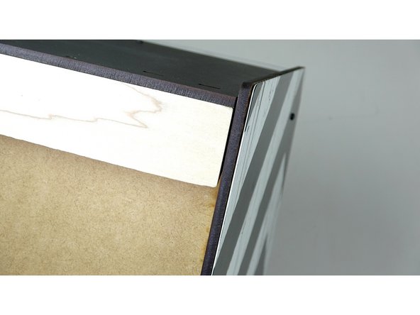 Insert the beam flat against the back panel, in between the two side panels. The angled part of the wood piece should be facing inward and down.