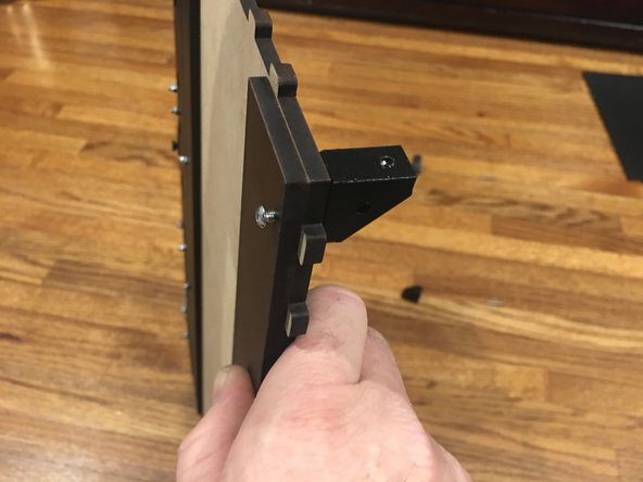 Line up the  Rear Track Guide panel with the bolt holes on the back of the base panel. It will be mounted on the UNFINISHED side of the base panel.