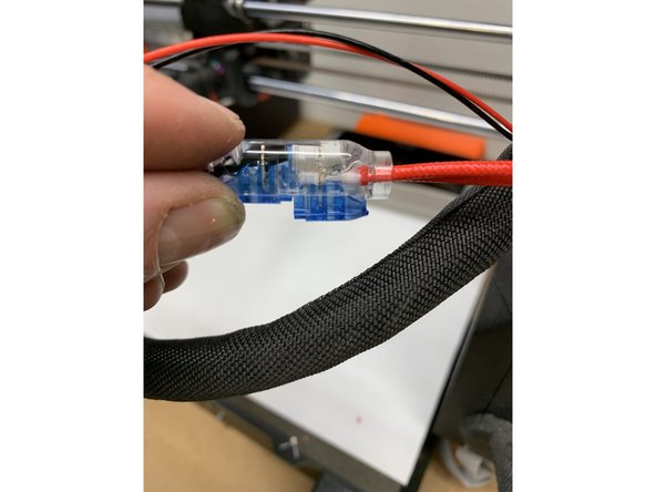 Fully insert the Prusa heater wires into the Black wire Splice (one wire in each hole) and squeeze firmly to crimp. Pliers might be required to fully seat the blue cap into the clear body.