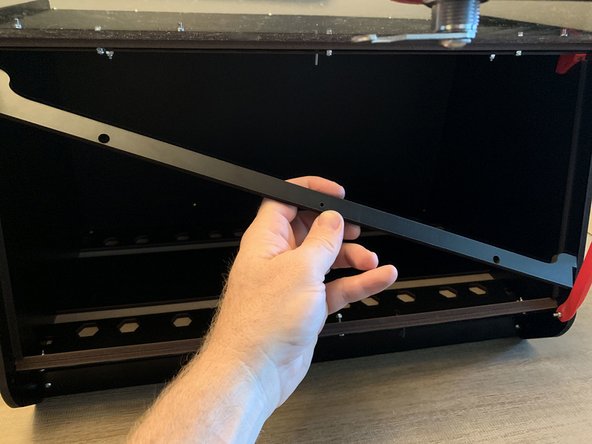 The top seal bar holds the side bars in place. If installed remove the screw and nylock from the center of the current lid clamp assembly.