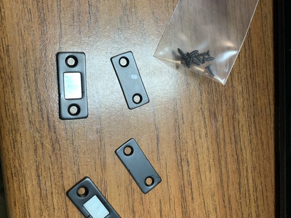 Remove the magnets and catch plates for now, but set aside the adhesive strips and included screws for the time being.
