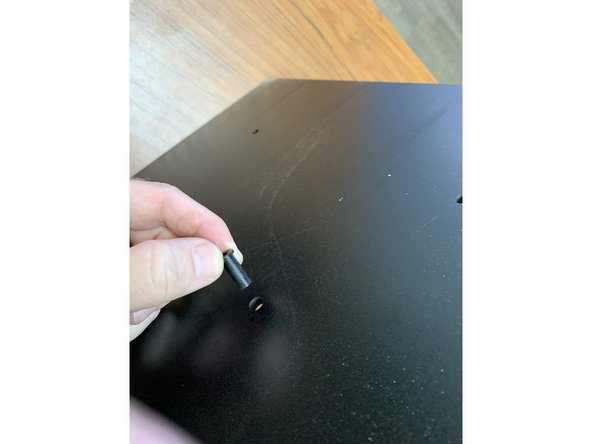 Locate the 3D-printed hub axle (Part 20) and press it through the center hole as shown. Hold it in place with a finger as you flip it over and lay it on a table to keep it in place. See the following video for more detail.