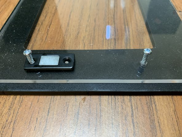 Lay the Mag Catch magnetic sides (the other side of Part 15 from earlier) atop the acrylic as shown in picture 3 and press in the two shorter handle screws from the previous step on each side to line everything up.