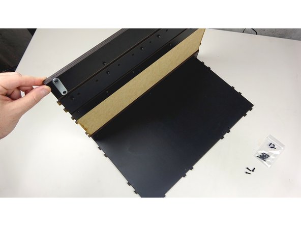 Lay the Back panel down, finished side up, and then insert the finished Base assembly into the tab holes as pictured.