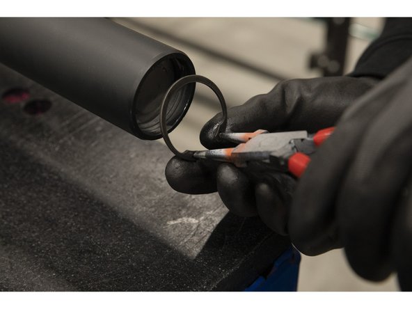 Using the snap ring pliers, carefully install the square-end snap ring into the assembly with a hand over the sleeve end as shown.