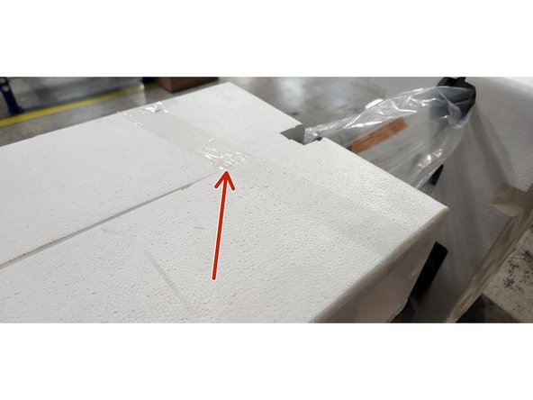 The foam clamshell is held in place using packing tape.  Cut the packing tape at the clamshell seam.