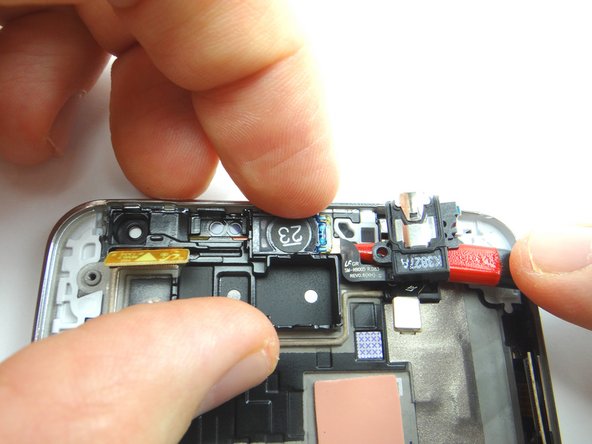 Use the pointed end of the spudger to gently pry up the headset jack.