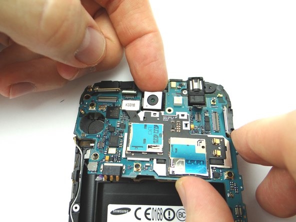 Use your index finger to gently ease the camera out of its position while lifting the logic board.