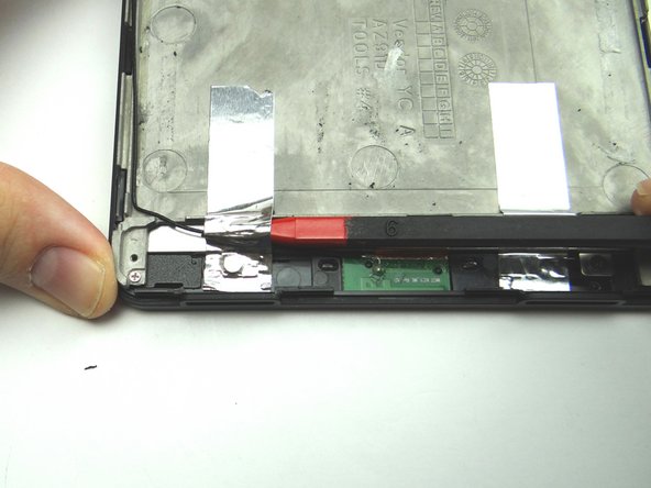 Use the pointed end of the spudger to peel up silver tape securing antenna cable.