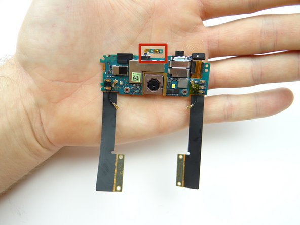 Lift the bottom of the daughter board with your finger, while using the blue pry tool to lift the power button contact away from the mid-frame.