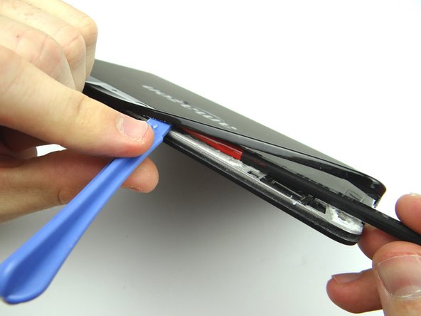 Picture 3: Use the flat end of the spudger to cut through adhesive.