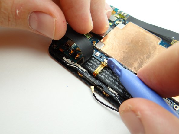 Use the blue pry tool to snag the tab on the cable and gently pull it free.