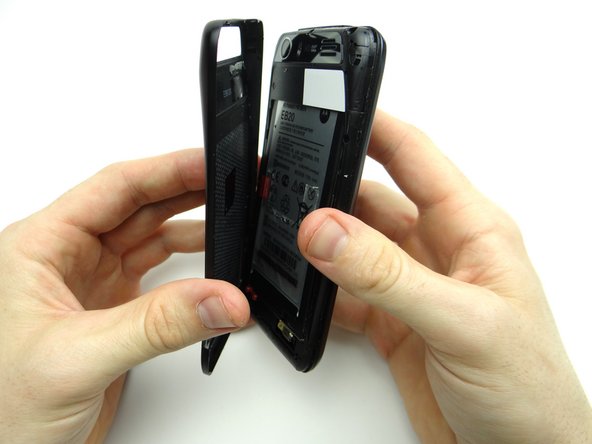 Continue peeling off battery cover, releasing the clips holding it in place.
