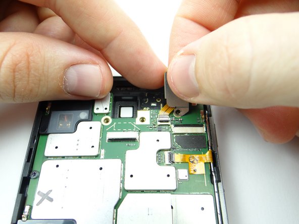 Picture 3: The headphone jack cable is attached to the headphone jack cover.  Lift the cover while guiding the cable out of the ZIF connector.