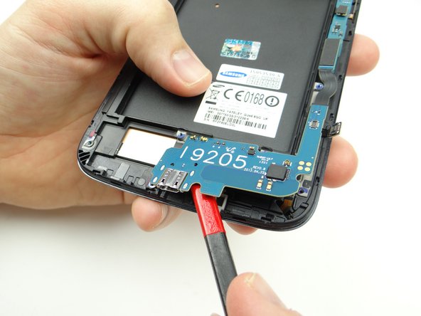 Pictures 2 &amp; 3: Slowly work up the charging port assembly to free it from the mild adhesive holding it in place.