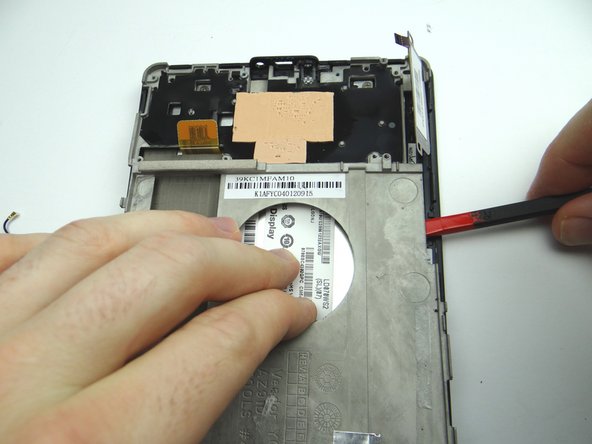 Picture 3: Wedge the flat end of the spudger between the mid-plate and front panel.  Pry up the mid-plate using the spudger in your right hand while pulling up with your left.