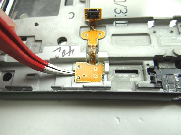 Wedge the curved tip tweezers in between the tabs on the left side.  Lift just enough to wedge the blue pry tool underneath.