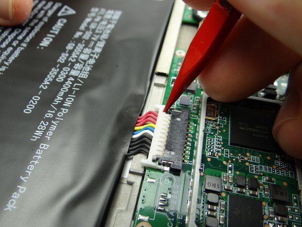 Pictures 1 &amp; 2: Wedge the pointed end of the spudger on either side of the battery connector to unhook it.