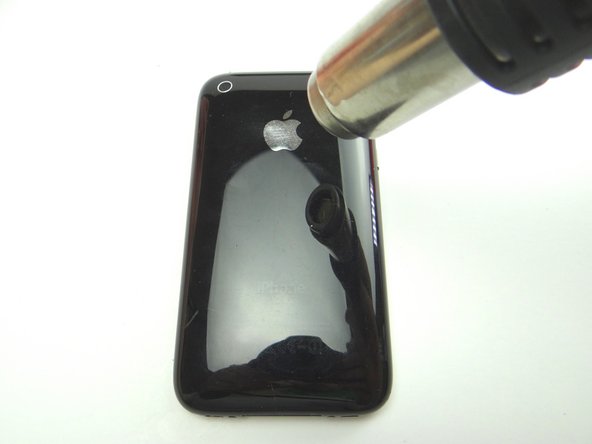 Picture 1: Adhesive around the perimeter of the battery holds it to the rear case.  Apply low-level heat (100° Celsius) to the underside of the rear case for 30 seconds to loosen the adhesive.
