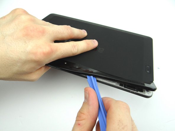 Picture 1: Use the wide blue pry tool to work your way towards the camera.