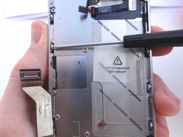 Pictures 1 and 2: Loosen the three large-head Phillips screws along the left side of the iPhone about one half turn, taking care not to remove these screws.