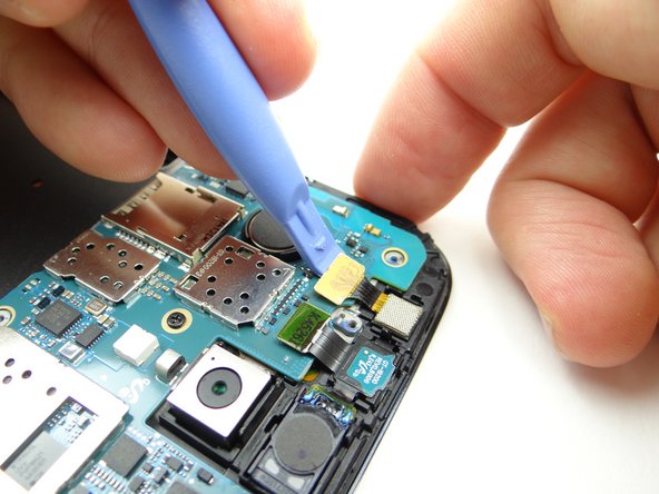 Disconnect front-facing camera with blue pry tool.