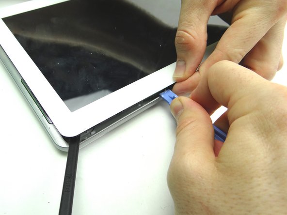 Picture 3: Sweep across the top with the blue pry tool, while gently pulling up the front panel with your fingers.