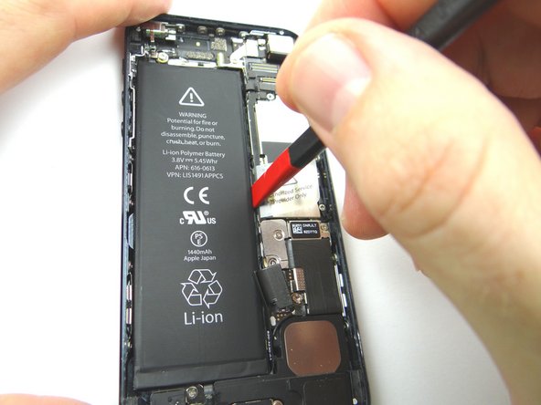 Work your way along the right and top of the battery, gently prying up with the Black Spudger to free the battery from the adhesive securing it to the rear case.