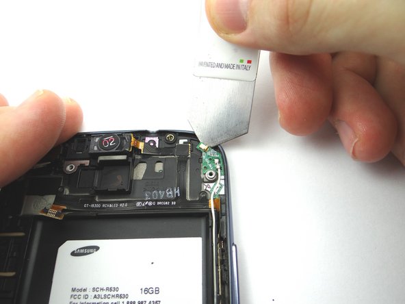 Picture 1: Use the iSesamo to separate the adhesive securing the wifi antenna board from the phone. Do not lift up on the board until it is free of the phone.