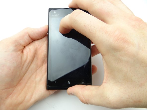 Picture 2: Use both hands to close the display on the rear case, guiding the front-facing camera and proximity sensor into their sockets.