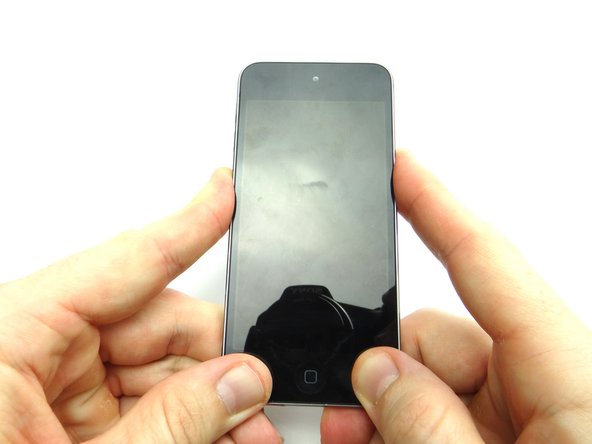 Press firmly on either side of the home button where the adhesive pads are located.