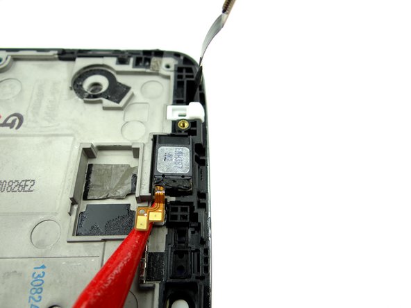 Use the pointed tip of the spudger to wedge under the earpiece speaker cable.