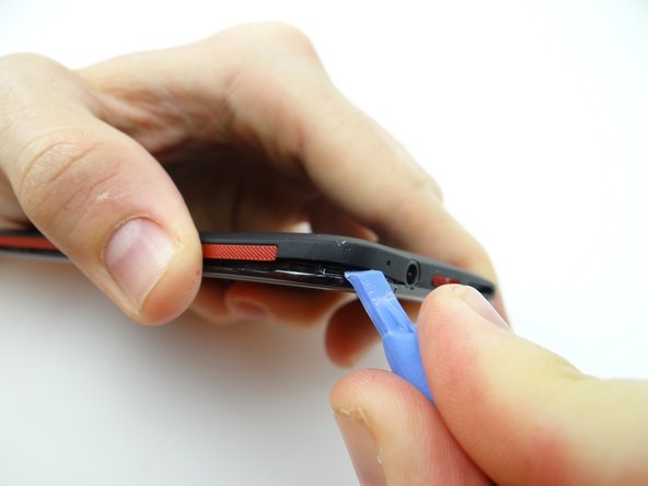 Pry up the corner near the headphone jack.