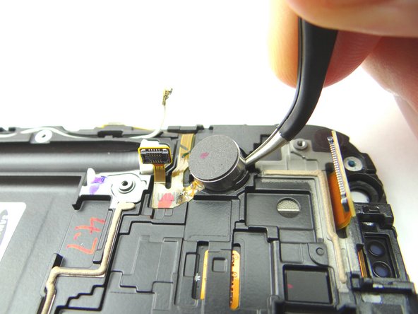 Use the Curved Tip Tweezers in the closed position to pry up on vibrator from its position.