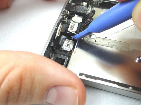 Picture 1: Wedge the Blue Pry Tool beneath the speaker (held by adhesive). Gently pry upwards. Place into COMPARTMENT D.