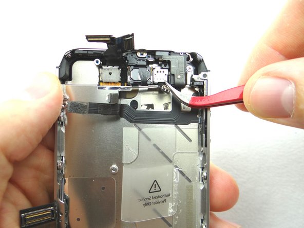 Pictures 1 and 2: Use a pair of tweezers to remove the metal plate covering the front facing camera; pull the bottom clip free first, then push the plate towards the top of the iPhone to free the top left clip, then pivot right to free the top right clip.