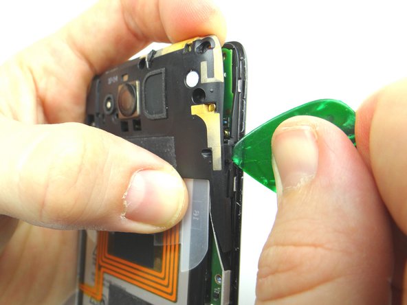 Use the guitar pick to free the marked clip while pulling the top edge of the panel with your finger