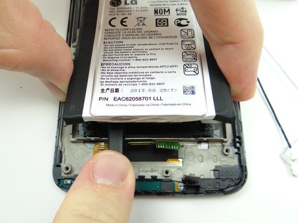 Use the flat end of the spudger to work your way through the adhesive.