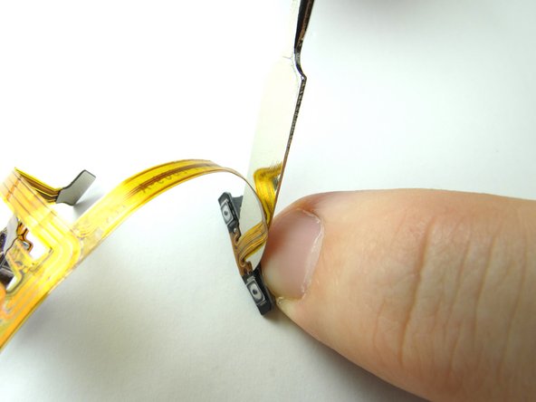 Use the metal spudger to separate the volume button bracket from the volume button cable.  Place both in COMPARTMENT D (with volume buttons).