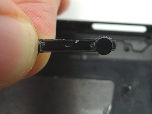 Pictures 1 &amp; 2: Retrieve volume button rocker from ZONE V.  Note the orientation of the half-circle in the center when seating it.