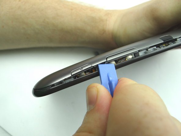 Picture 1: Insert   between the volume rocker and power button.  Gently twist to pry up.