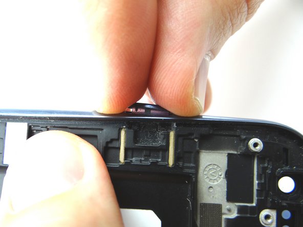 Reattach the power button from COMPARTMENT G by pushing it in with your fingers.  Note the overbite at the bottom of the power button - this is the correct orientation.