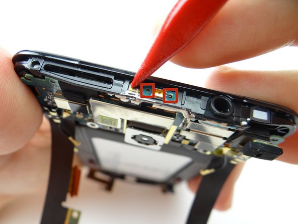 Push the power button contact into place.  Make sure the openings on the power button contact line up with the tabs on the mid-frame (red squares).