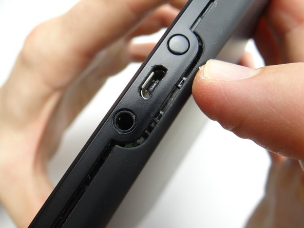 Start with the two tabs on either side of the charging port.