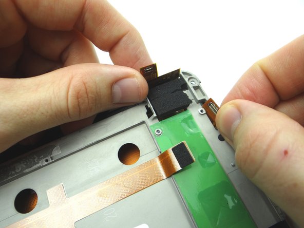Carefully guide the LCD and digitizer cables through their openings in the upper-right corner.